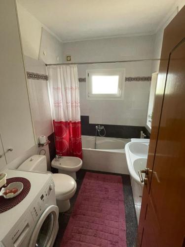 a bathroom with a white toilet and a tub and a sink at Palio Luxury Apartment in Paleo Tsifliki