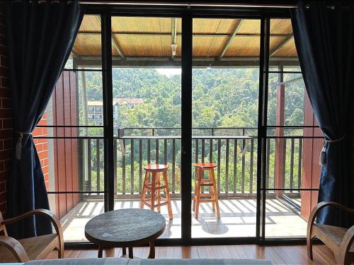 uma varanda com duas cadeiras e uma mesa e dois bancos em กัปตัน มายลอฟท์ โฮมสเตย์ em Ban Pilok Khi