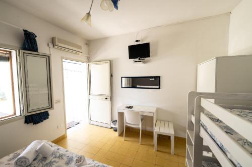 a bedroom with a bed and a desk in a room at Villa Giulia Tonnara di Bonagia in Valderice