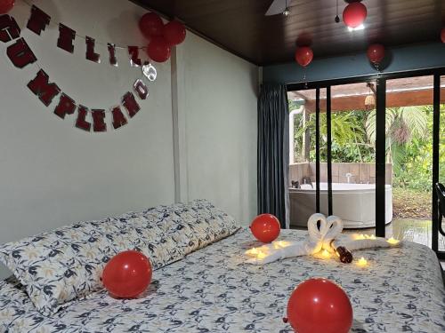 a bedroom with a bed with red balloons on it at El Castillo Harmony in El Castillo de La Fortuna