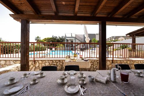 a table with plates and silverware on top of a patio at Villa Giulia Tonnara di Bonagia in Valderice