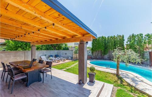 メドゥリンにあるHoliday Home Biskupija Bb Crのテーブルと椅子とプールのあるパティオ