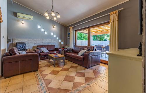 メドゥリンにあるHoliday Home Biskupija Bb Crの革製の家具と大きな窓のあるリビングルーム