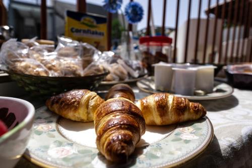 a table with plates of bread and pastries on it at Villa Giulia Tonnara di Bonagia in Valderice