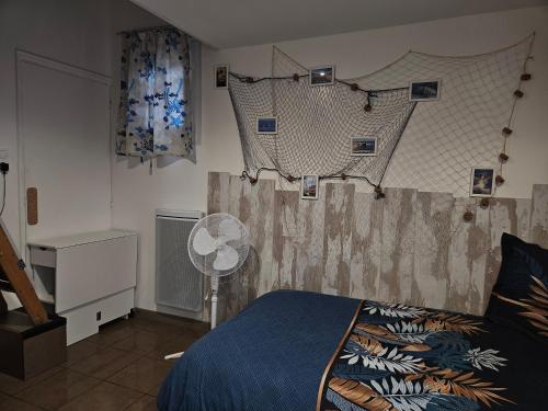 - une chambre avec un lit, un ventilateur et des rideaux dans l'établissement entre mer et montagne, à Saint-Estève