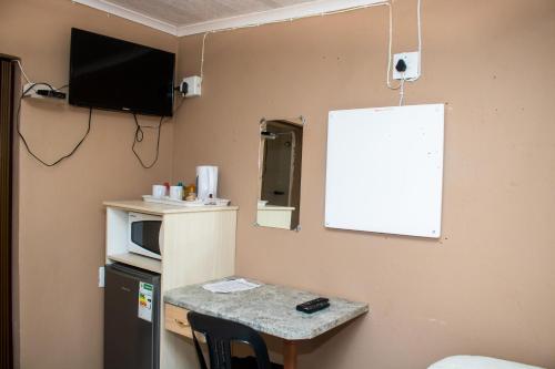 a room with a table and a whiteboard on the wall at Vochelo Lodge in Phuthaditjhaba