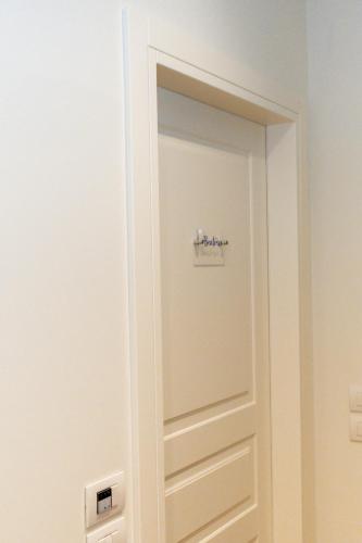 a white door with a sign on it in a room at C House Rooms Lake in Peschiera del Garda