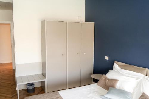 a bedroom with a white cabinet next to a bed at C House Rooms Lake in Peschiera del Garda