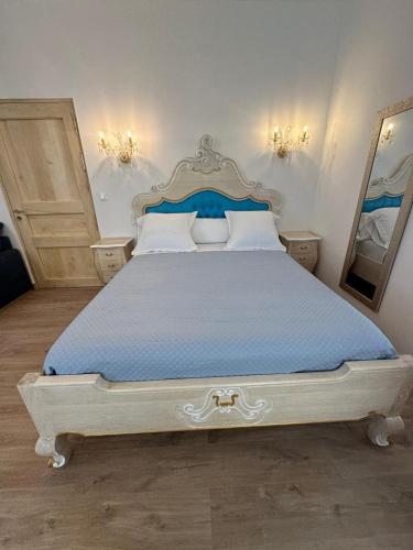 une chambre avec un grand lit avec un couvre-lit bleu dans l'établissement Appartement du Cloitre 1er, à Narbonne