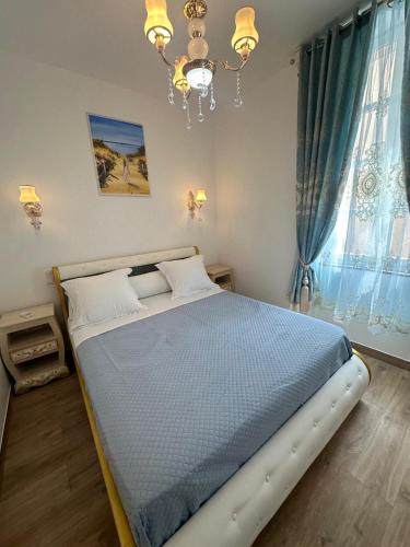 Ce lit se trouve dans une chambre dotée d'un lustre. dans l'établissement Appartement du Cloitre 1er, à Narbonne