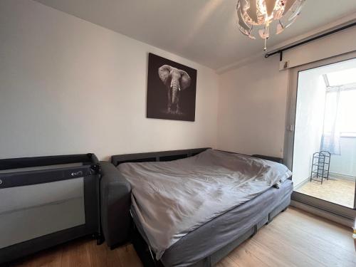 - une chambre avec un lit et une photo d'éléphant sur le mur dans l'établissement Votre Pied-à-Terre en Bord de Mer, à Sète