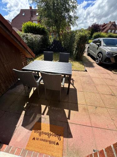 a picnic table and chairs on a patio at Strandhaus Nina - Ferienhaus Hooksiel in Hooksiel