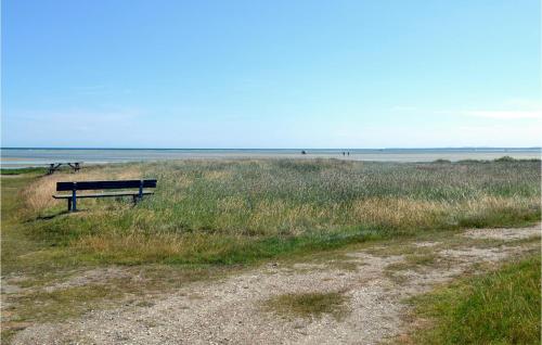 a bench sitting in the grass near the beach at Holiday Home Bogfinkevej Ørsted Xi in Kare