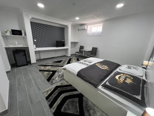 a bedroom with a bed and a living room at Adél Apartman in Kisújszállás