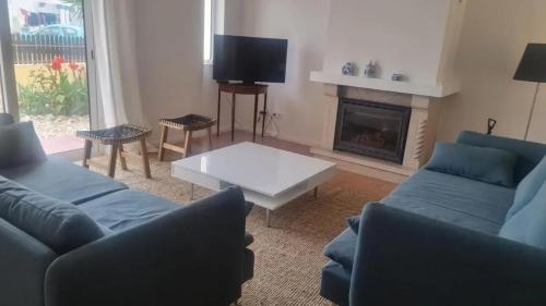 a living room with two blue couches and a fireplace at Seaview Villa with Private Pool in Moncarapacho in Moncarapacho