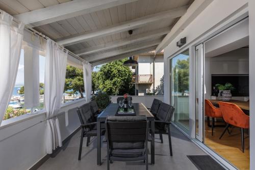 a dining room with a table and chairs on a balcony at Apartments Sax 1 in Crikvenica