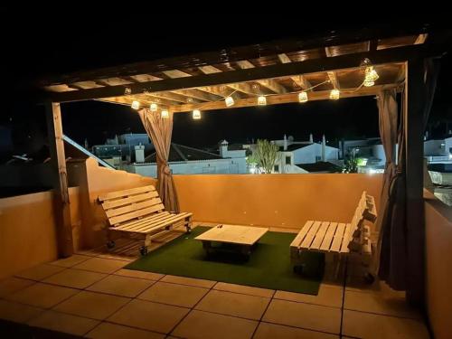 a patio with benches and a table and lights at Seaview Villa with Private Pool in Moncarapacho in Moncarapacho