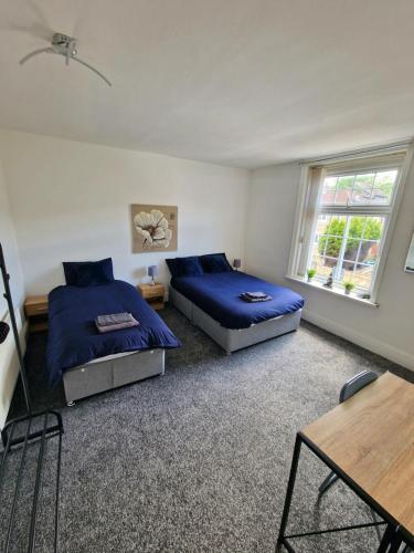 a bedroom with two beds and a table at Free Parking at this Stylish Terraced House in Bradford, with views of hillside in Shipley