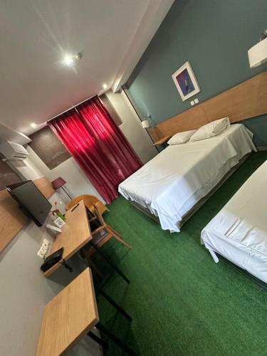 a hotel room with two beds and a desk with a desk at Athina Airport Hotel in Thérmi