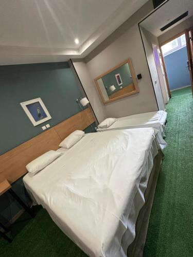 a bedroom with a large bed with white sheets at Athina Airport Hotel in Thérmi