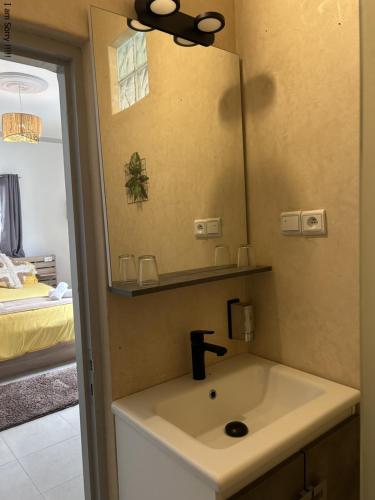 a bathroom with a sink and a mirror at Riad Ghazal in Essaouira