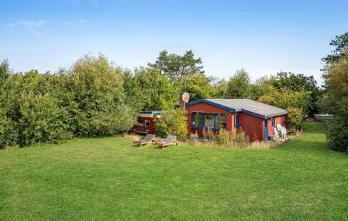 a red cabin in the middle of a grass field at Cozy Home In Slagelse With Wifi in Slagelse