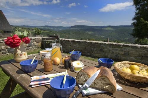 une table en bois avec du pain et des verres bleus dessus dans l'établissement La grange du candel bos a nogardel, à Saint-Pierre-de-Nogaret