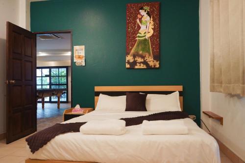 a bedroom with a large bed with a green wall at Royal Adobe Pool Villa in Jomtien Beach