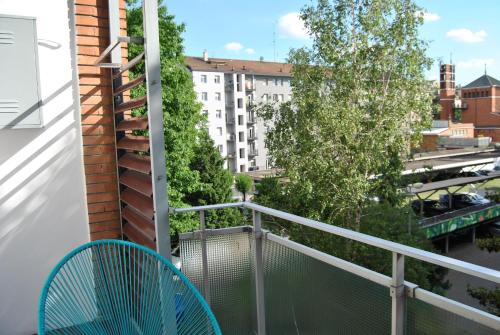 a balcony with a blue chair and a building at Portello Flat with Balcony in Milan
