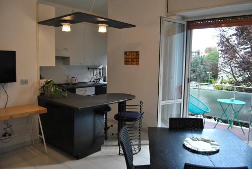 a kitchen and dining room with a table and a window at Portello Flat with Balcony in Milan