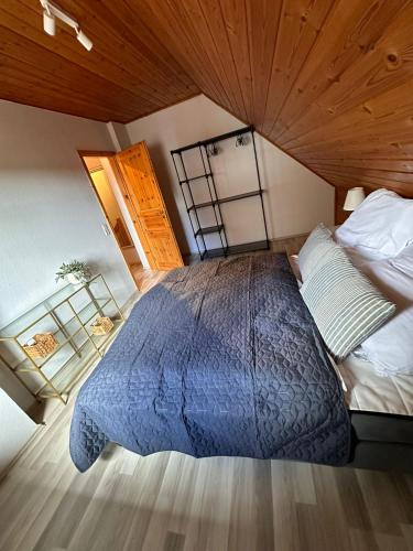 a bedroom with a large bed and a wooden ceiling at Strandhaus Nina - Ferienhaus Hooksiel in Hooksiel