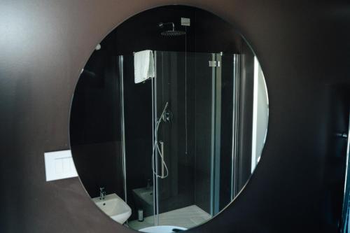 a mirror in a bathroom with a shower and a sink at C House Rooms Lake in Peschiera del Garda