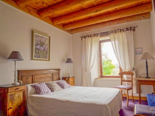 une chambre avec un grand lit et une fenêtre dans l'établissement Le pradel, gites de france a termes, à Termes