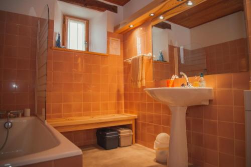 une salle de bain avec un lavabo et une baignoire dans l'établissement Le pradel, gites de france a termes, à Termes