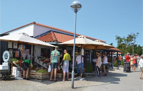 a group of people standing outside a market with umbrellas at Holiday Home Langesøvej in Rørvig