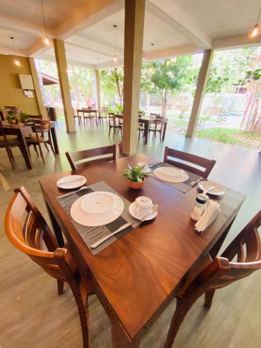 a dining room with a wooden table and chairs at Tropicara Resort in Sigiriya