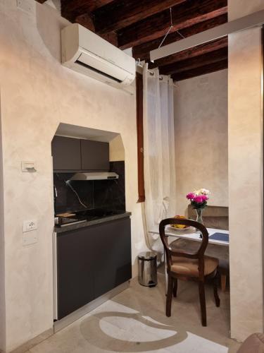 a kitchen with a table and a chair in a room at San Marco 3097 - LuxuryJacuzzi in Venice