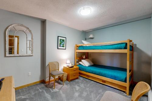 a bedroom with a bunk bed with a desk and a chair at Okemo Trailside 36E in Ludlow