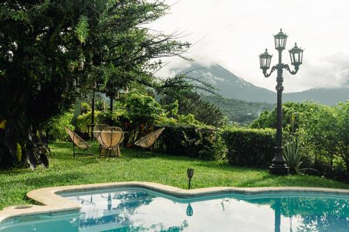Una piscina con una lámpara y una montaña. en Hotel Juayua, en Juayúa