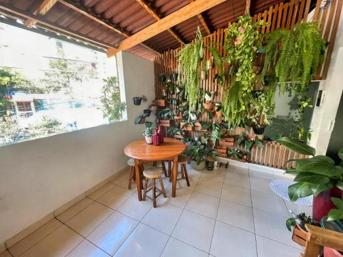 a room with a table and lots of plants at Casa da Marcinha in Sao Paulo