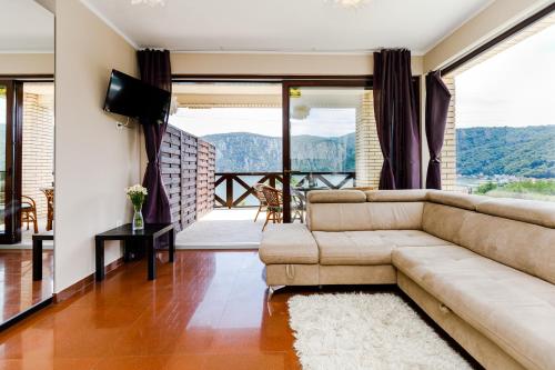a living room with a couch and a television at Pensiunea Decebal Resort - Cazanele Dunarii in Dubova