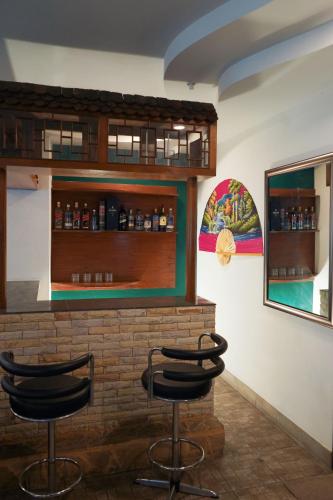 a bar with three stools in front of a brick wall at Royal Adobe Pool Villa in Jomtien Beach