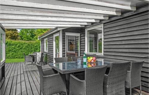 a patio with a table and chairs on a deck at 1 Bedroom Beautiful Home In Ølsted in Ølsted