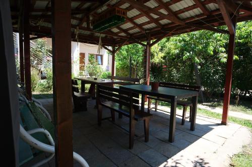 un patio con 2 mesas y sillas bajo una pérgola en Casa Ramia, en Vama Veche