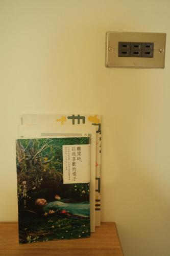 a clock hanging on a wall next to a table at Maru in Tainan