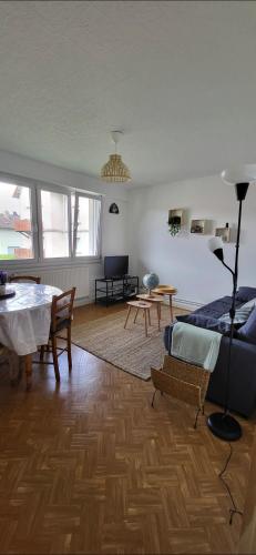 un salon avec une table et un canapé dans l'établissement le repère Gerardmer, à Gérardmer