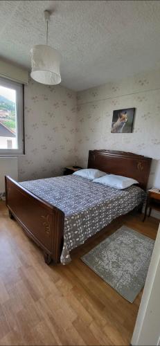une chambre avec un grand lit dans une pièce dans l'établissement le repère Gerardmer, à Gérardmer