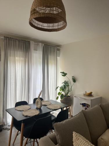 un salon avec une table et un canapé dans l'établissement Maisonnette à 10 minutes de Paris - La Défense, à Suresnes