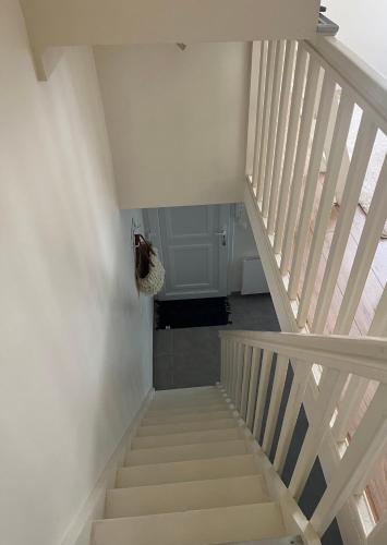 un escalier dans une maison aux murs blancs dans l'établissement Maisonnette à 10 minutes de Paris - La Défense, à Suresnes