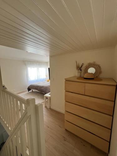 - une chambre avec un lit et une commode dans l'établissement Maisonnette à 10 minutes de Paris - La Défense, à Suresnes